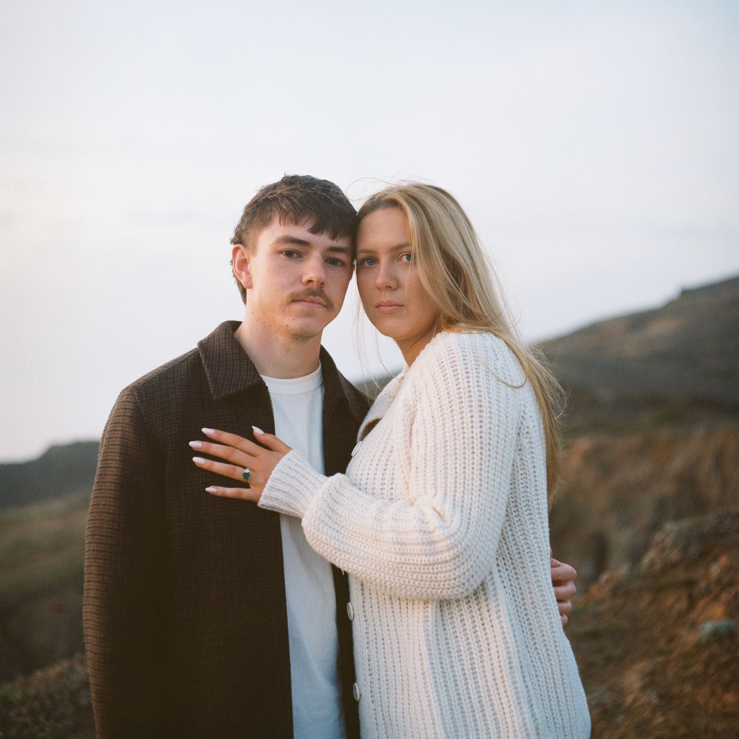 A couple poses on a cliffside in Northern California. Image is captured on the vibrant colors of Kodak's portra film stock