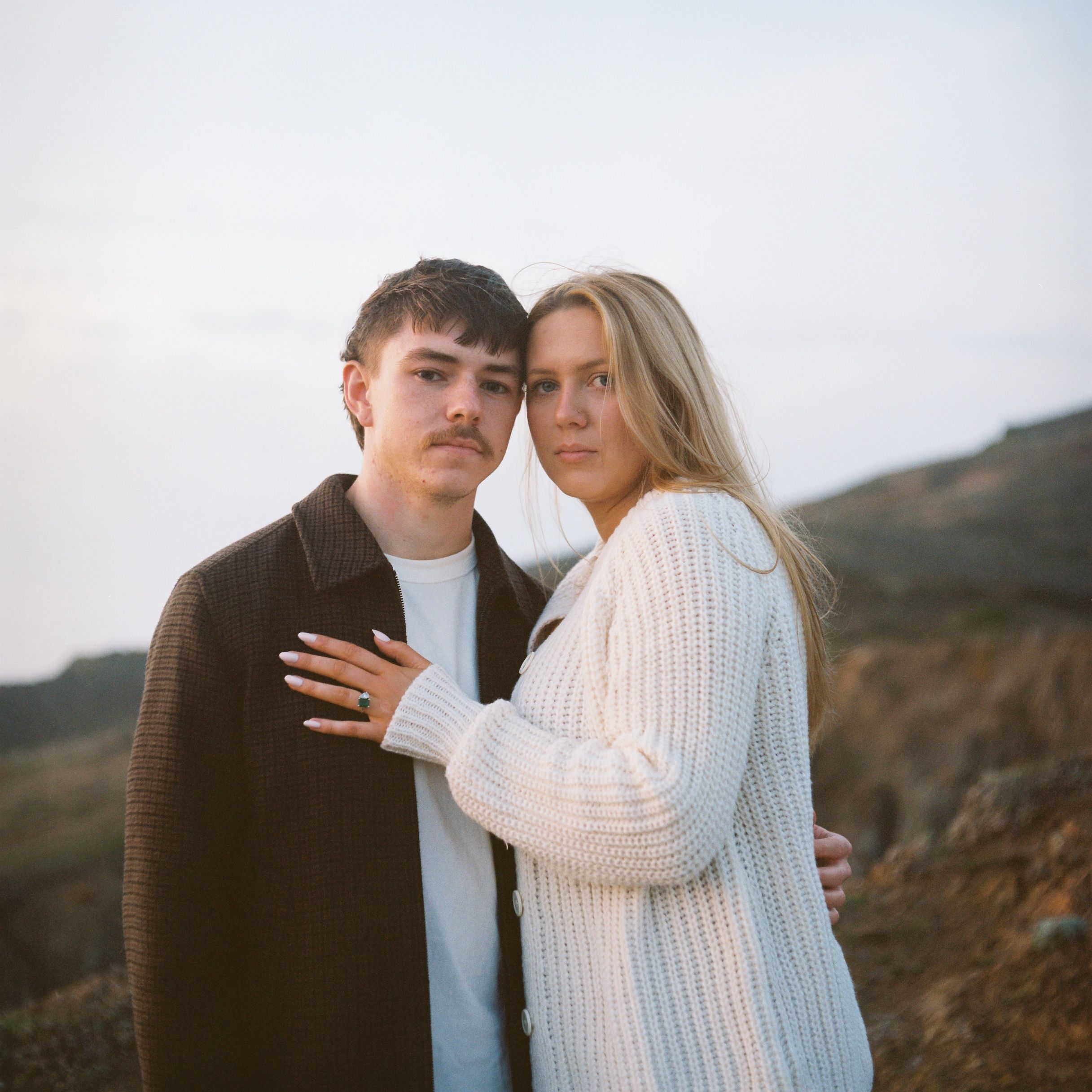 A couple poses on a cliffside in Northern California. Image is captured on the vibrant colors of Kodak's portra film stock