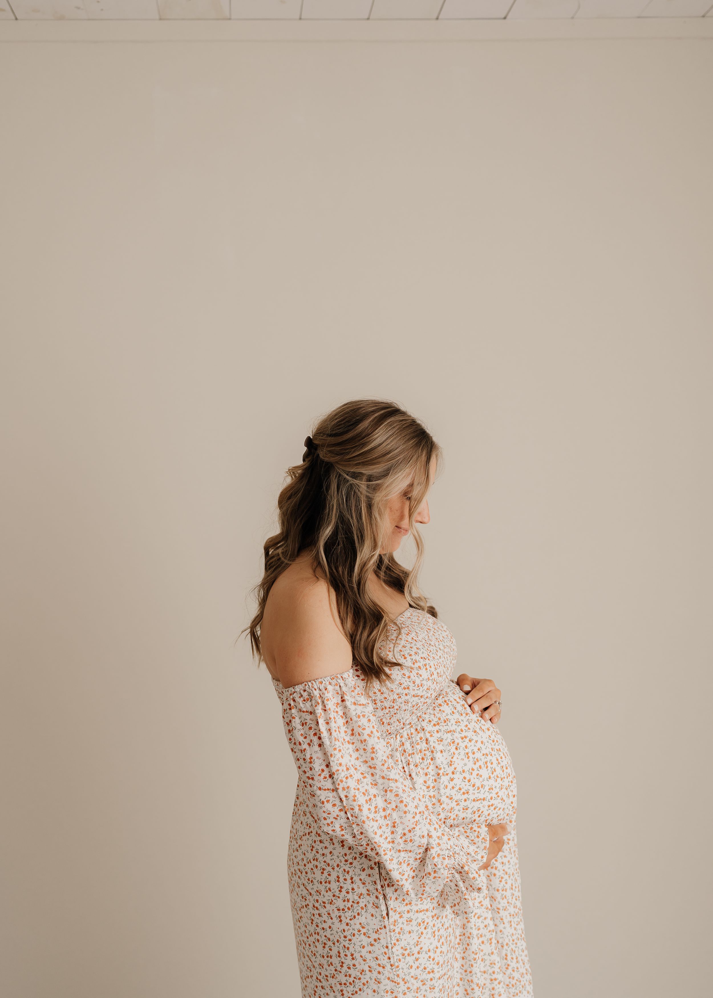 A sequence of four profile portraits showing someone wearing a white polka dot top against a neutral background.