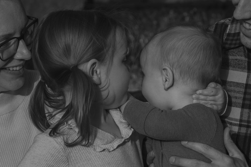 A tender black and white moment between family members in an intimate portrait.