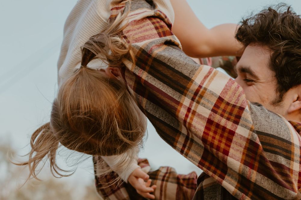 A joyful moment captured as two people interact against a bright sky.