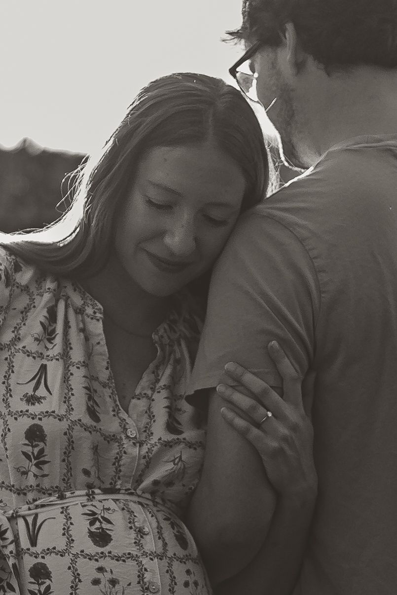 Two people share an intimate candid moment in black and white photography showing connection and emotion.