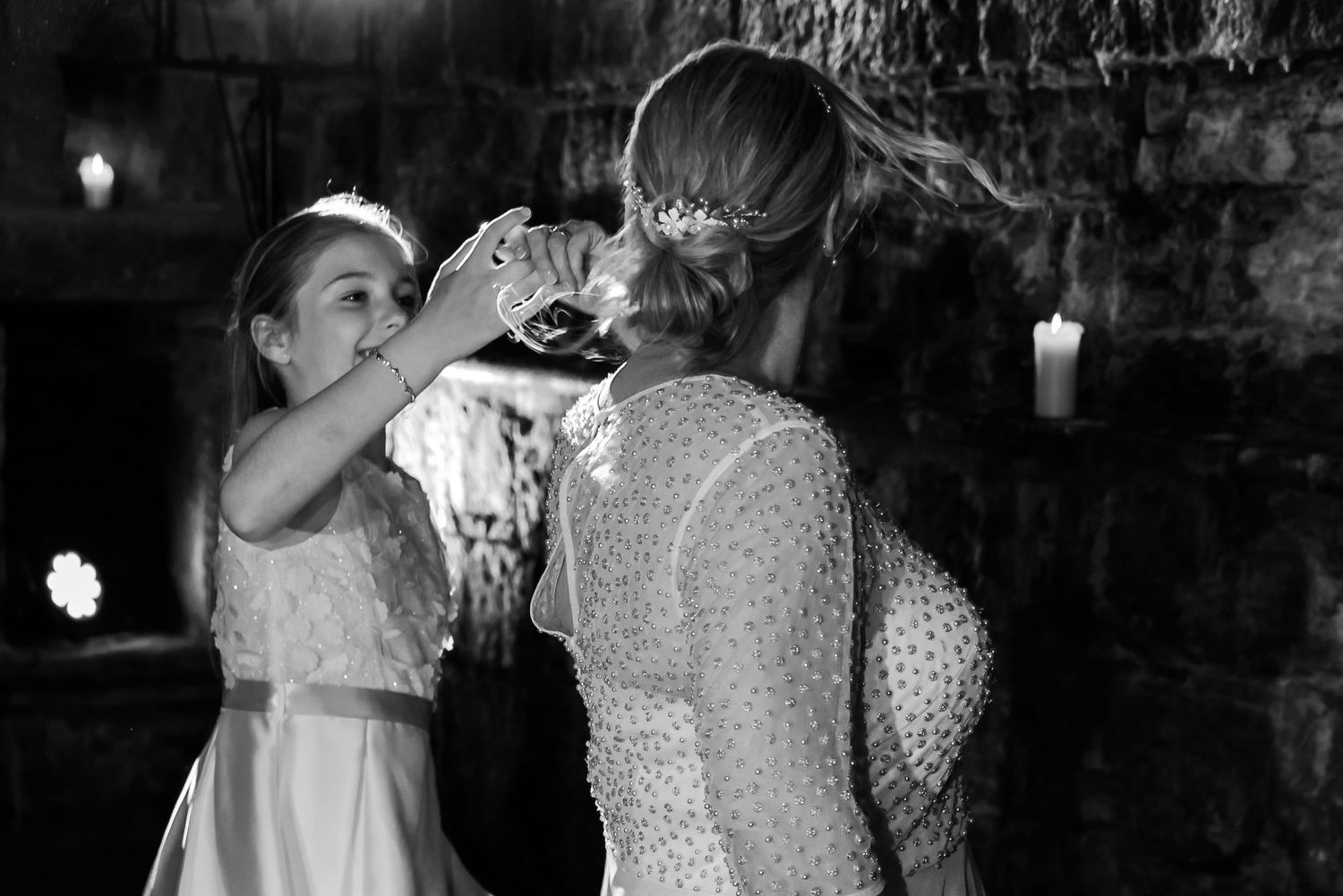 A black and white candid moment of wedding preparations in an atmospheric cellar setting.