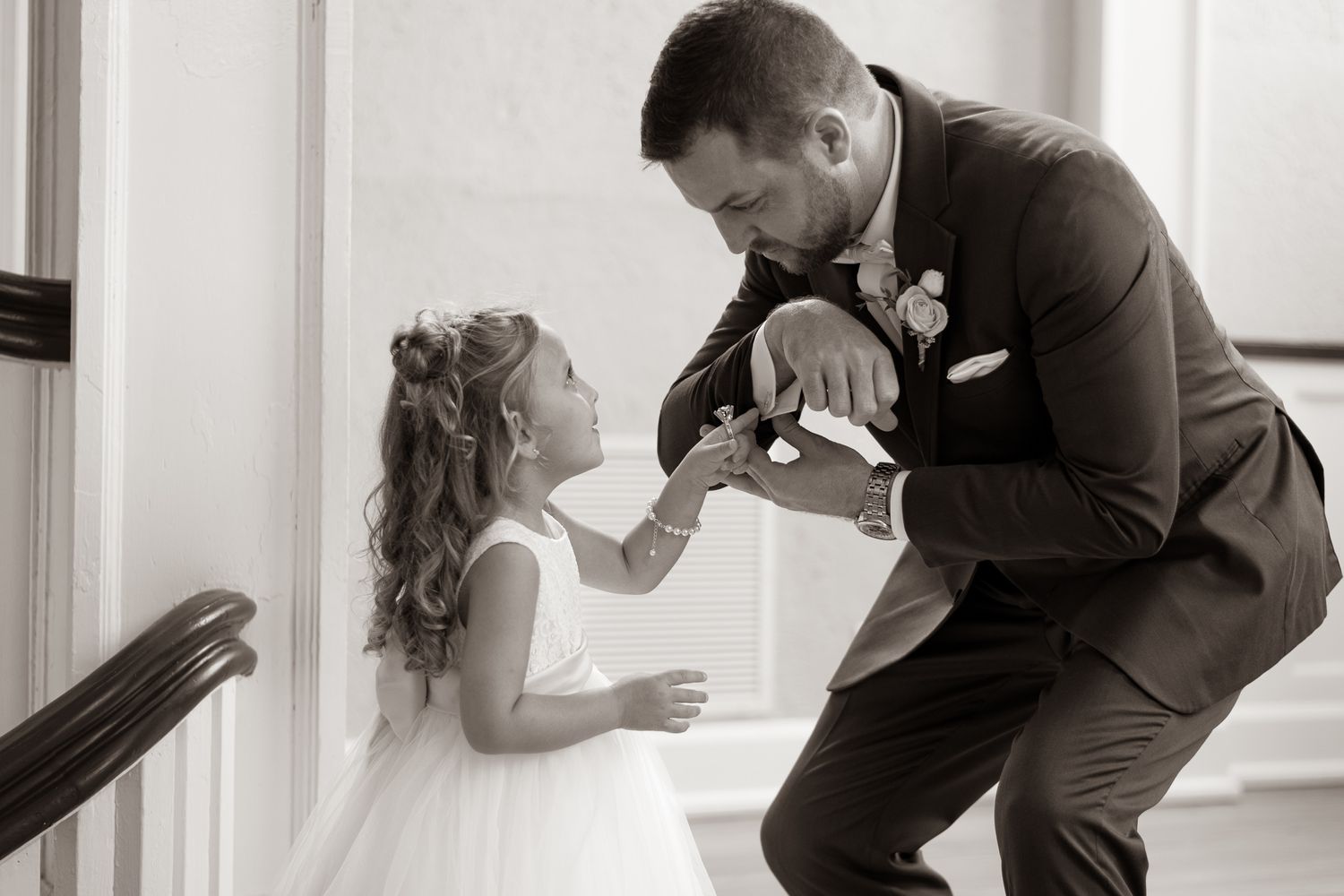 Sweet moment captured between an uncle and his niece on a grand staircase in black and white.