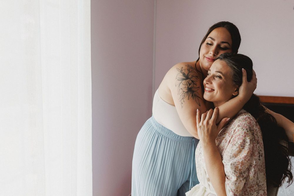 sister hugging the bride in a very emotional moment