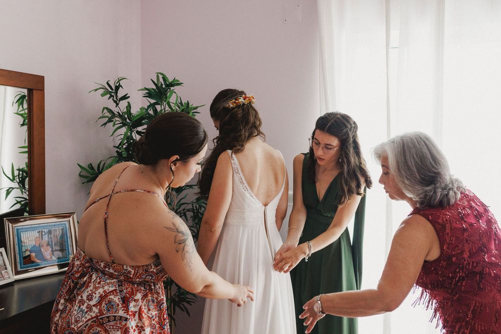 candid moment bride getting ready surrounded by family