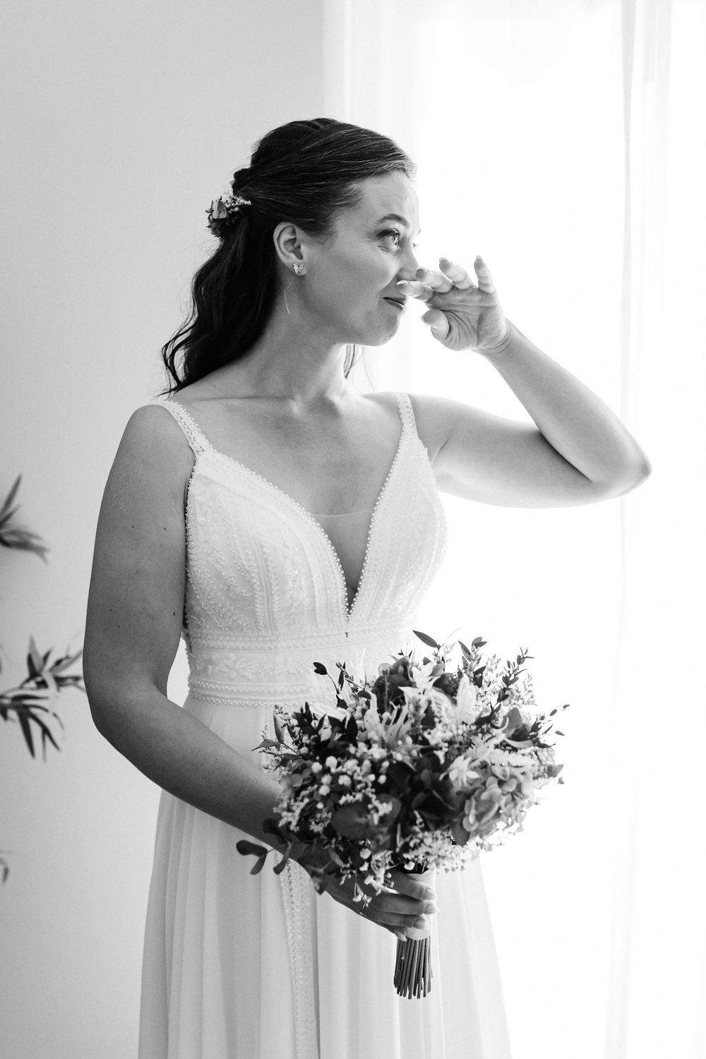 emotional and candid bride portrait looking to a window on her wedding day