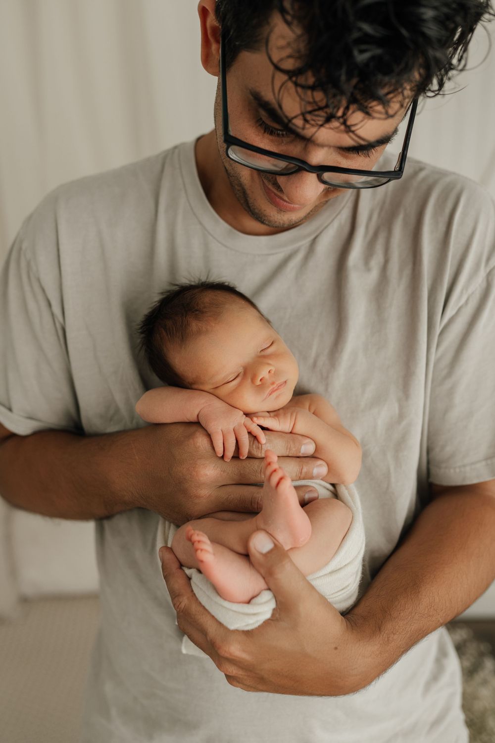 Peaceful moment with sleeping newborn in casual home setting.