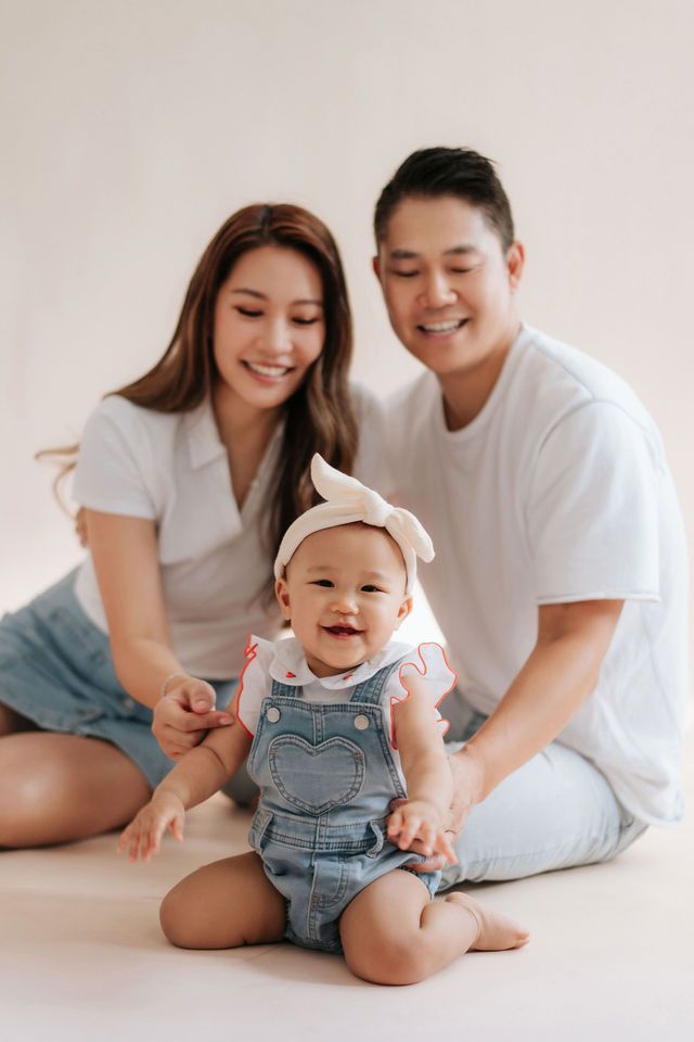 A tender moment between parent and child in soft white tones as they share cuddles and laughter on a couch.在柔和的白色調中，父母和孩子在沙發上擁抱、歡笑，溫馨的一刻。