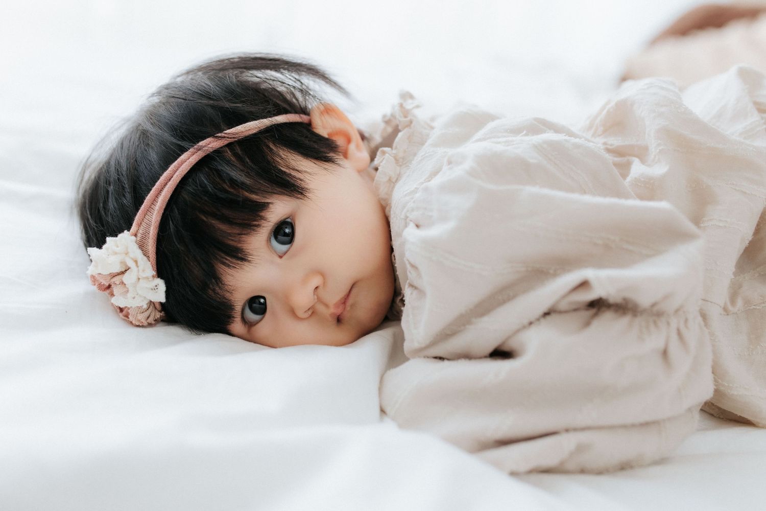 A series of tender moments between parent and baby shown in soft, warm lighting against neutral backgrounds.一系列父母與嬰兒之間溫馨的瞬間，在柔和溫暖的燈光和中性背景的襯托