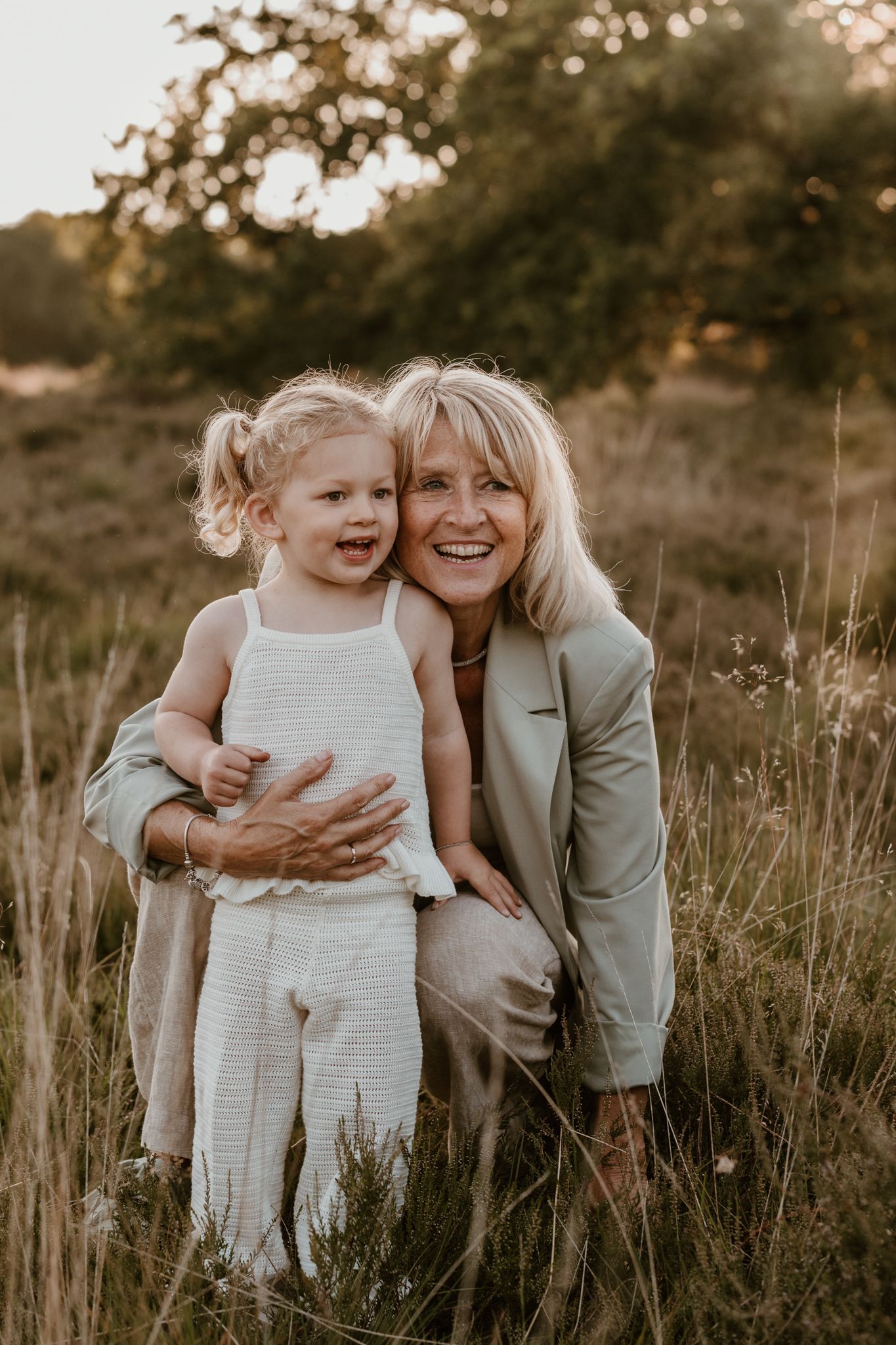 Kleindochter met oma tijdens een familieshoot. De kleding is rustig en in het gouden uur krijgen we stralende foto's in Assen
