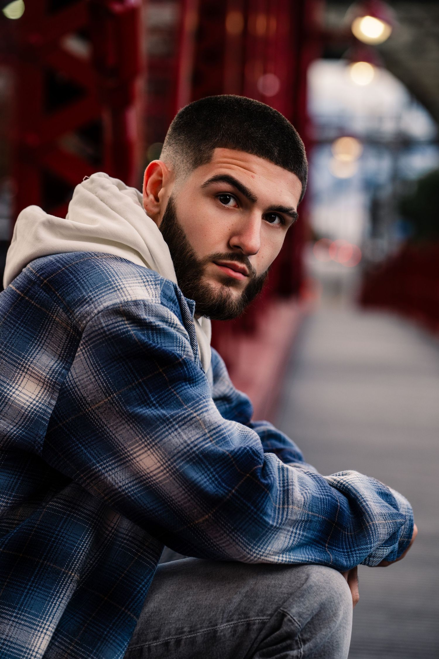 Moody portrait series showing someone in a blue plaid jacket against an urban backdrop.