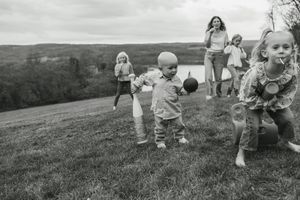 A series of black and white photographs showing children rolling down a grassy hill outdoors.