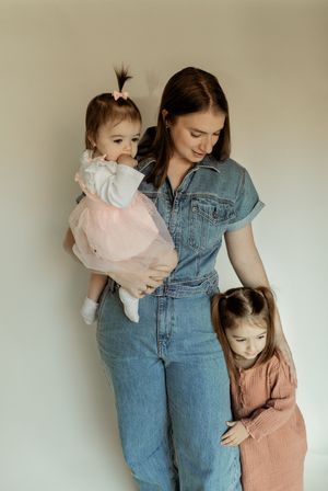 A series of tender moments showing a person in denim overalls embracing children against a neutral background.