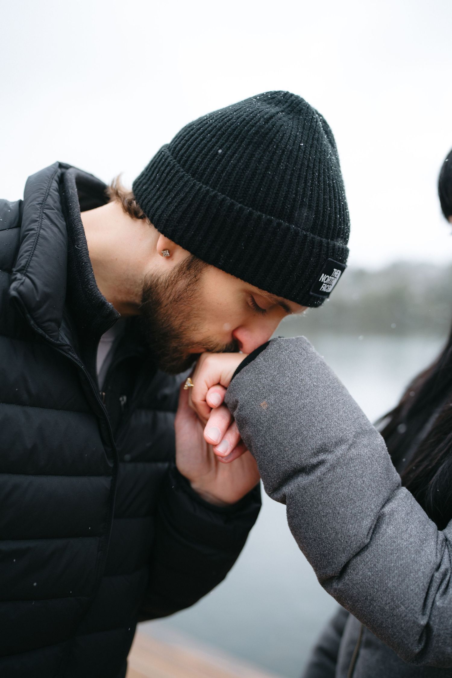 An intimate winter moment captured between two people wearing warm winter clothing.