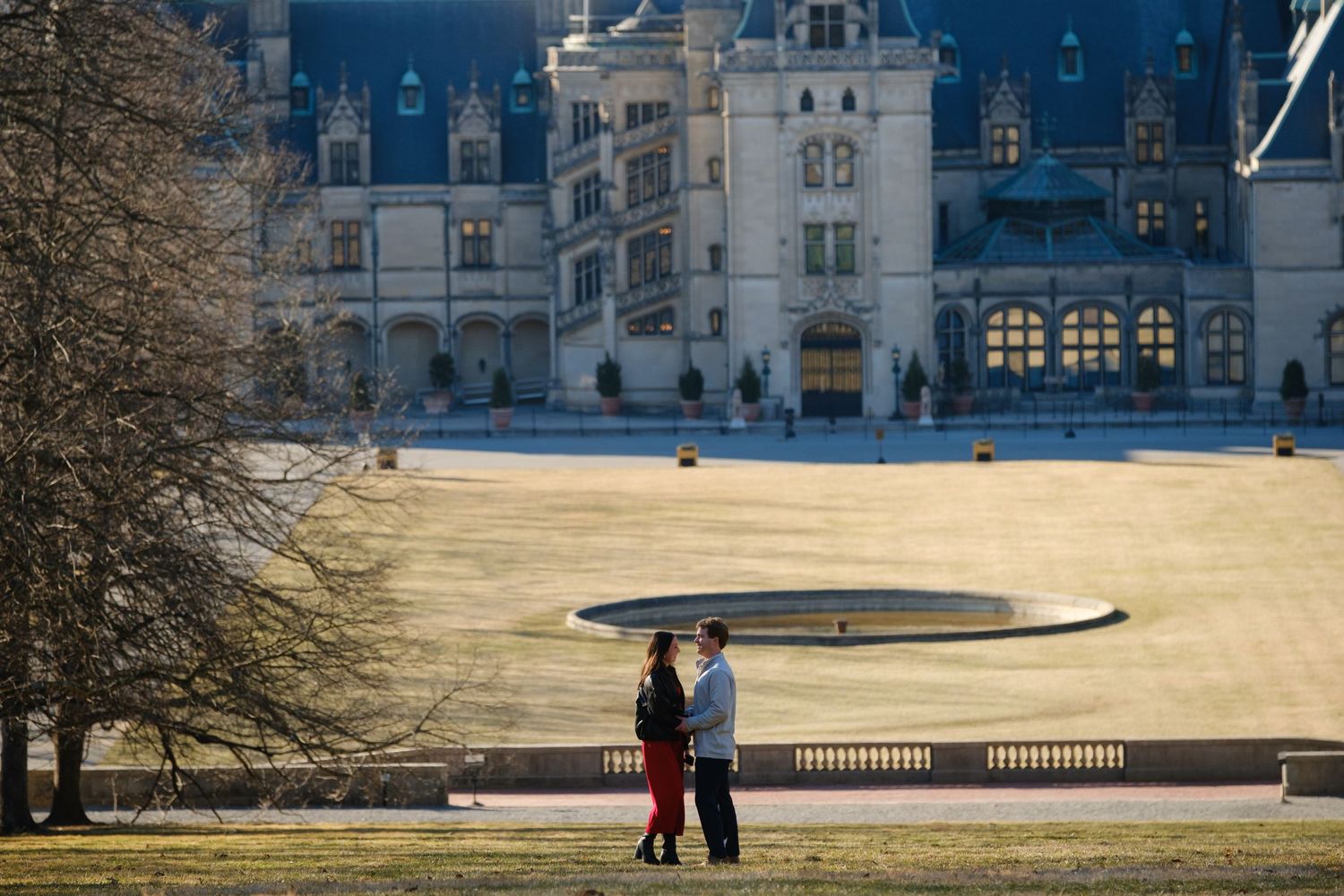 Couple celebrating surprise proposal at the Biltmore Estate in Asheville NC on a sunny February afternoon. Photographed by Stephanie A Smith