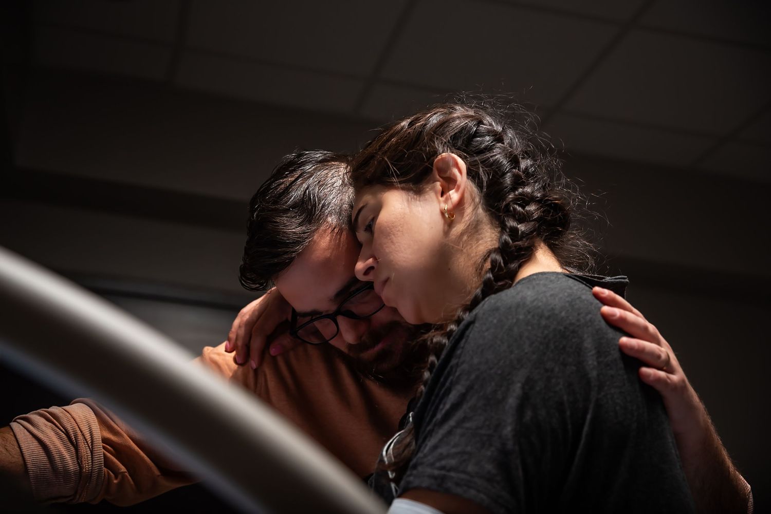 A photo of a mother leaning on her partner as she labors in the hospital to give birth.