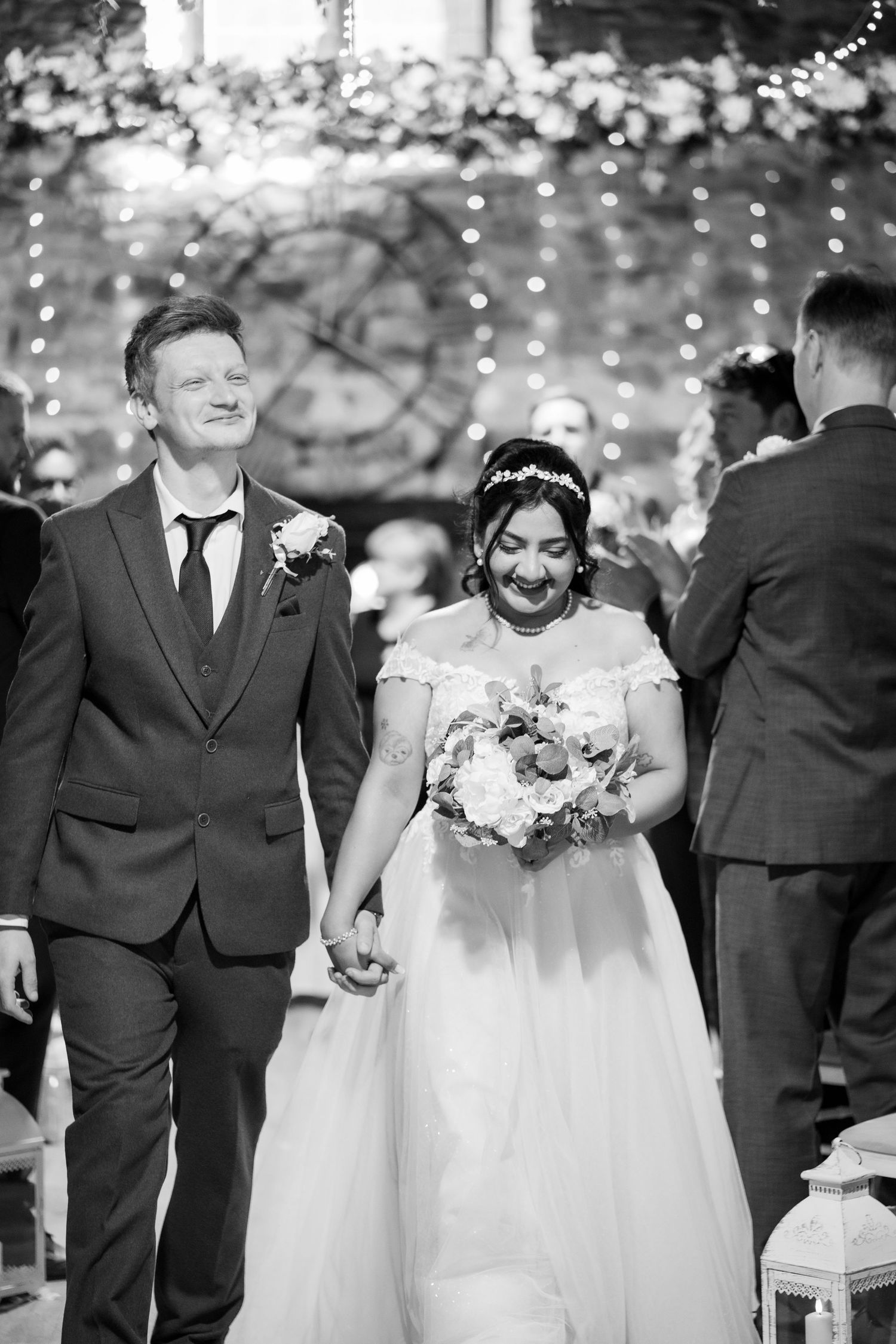 A romantic wedding couple shares intimate moments in a series of black and white photos under twinkling lights.
