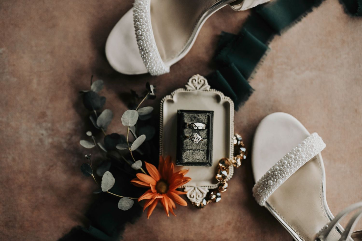 Elegant wedding flat lay featuring bridal shoes and engagement ring styled together during wedding morning detail photos.