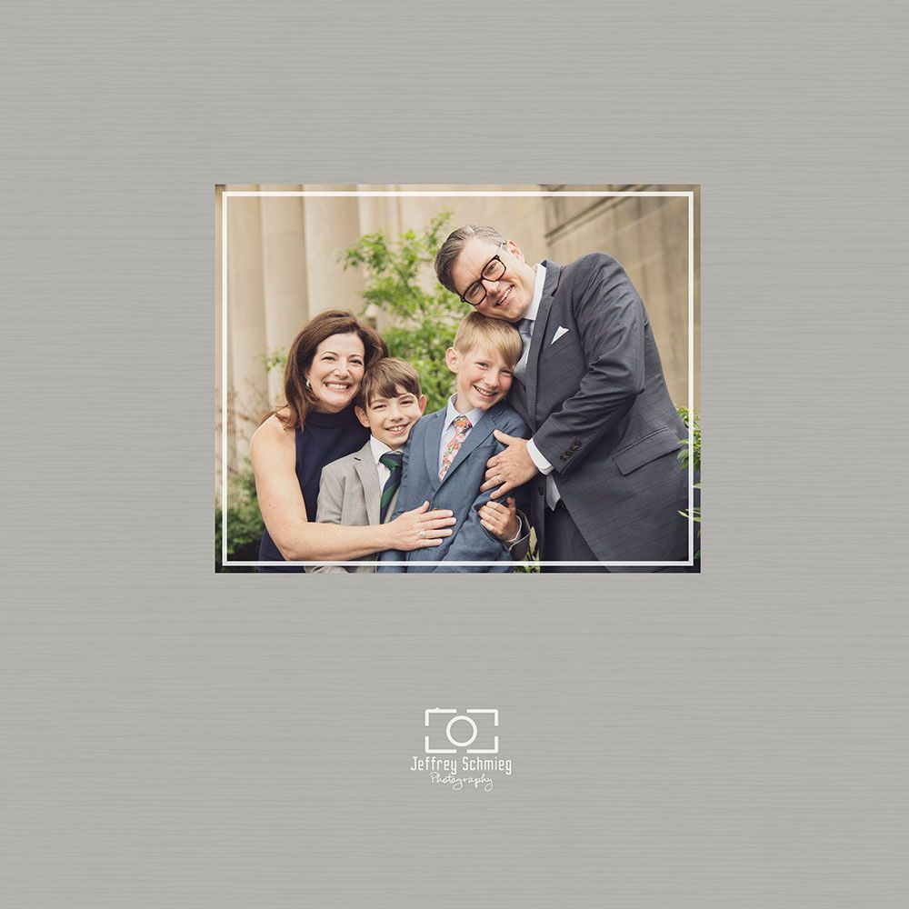 A family portrait with three people posing together in front of a neutral background.
