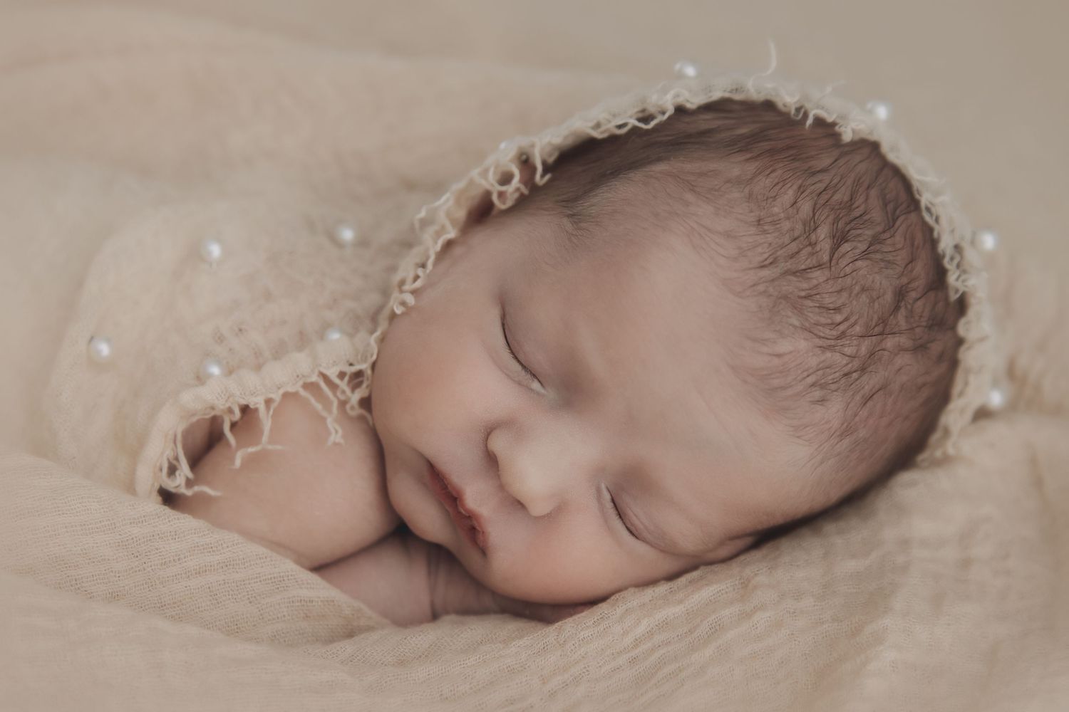 A series of black and white photographs showing a sleeping baby in various peaceful poses.