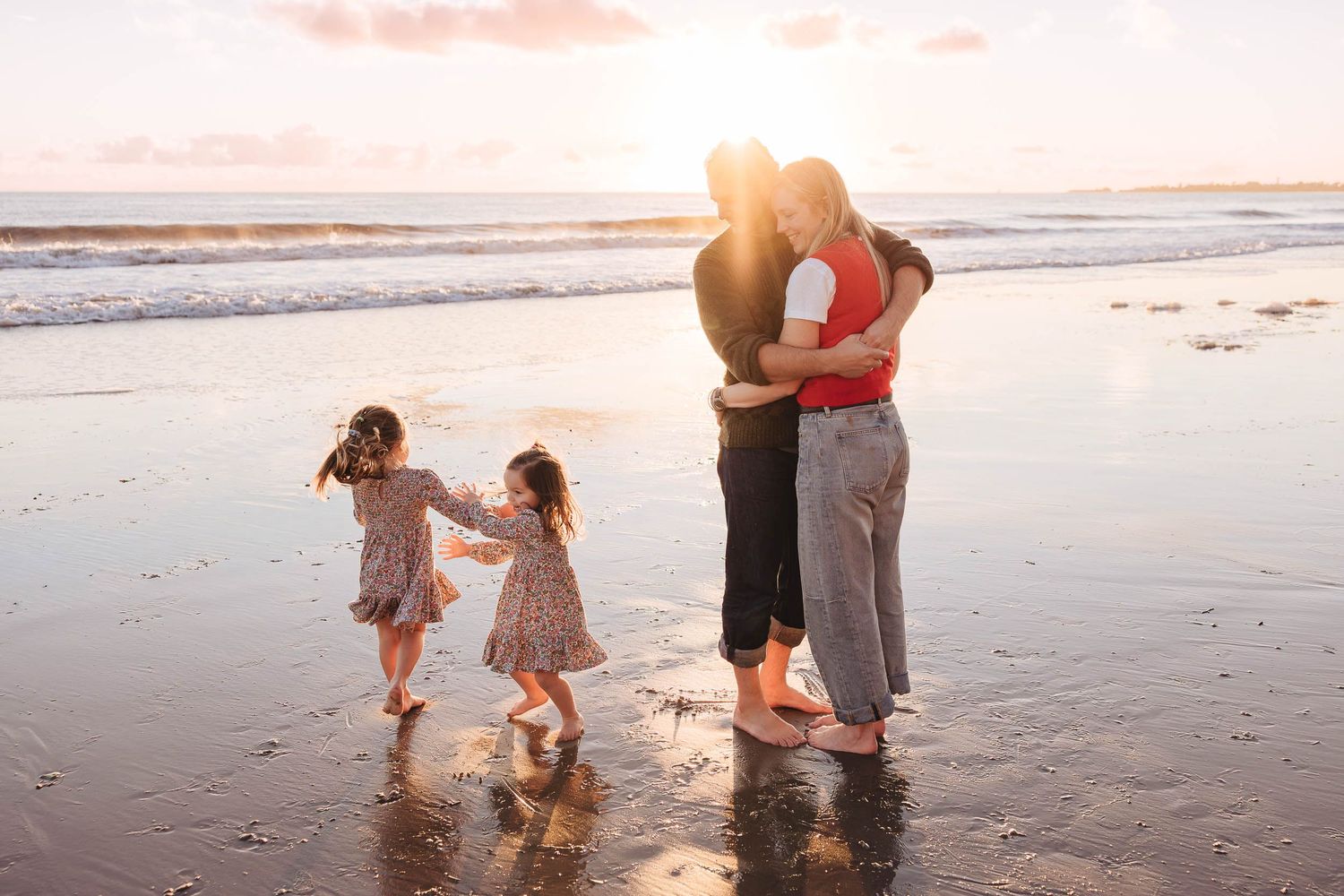 Family walking along a misty beach at sunset while collecting seashells and enjoying quality time together.