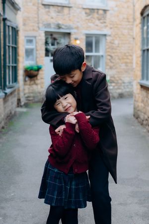 Cotswolds family photographer capturing portraits by the river in Bourton-on-the-Water.