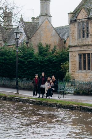 Cotswolds family photographer capturing portraits by the river in Bourton-on-the-Water.