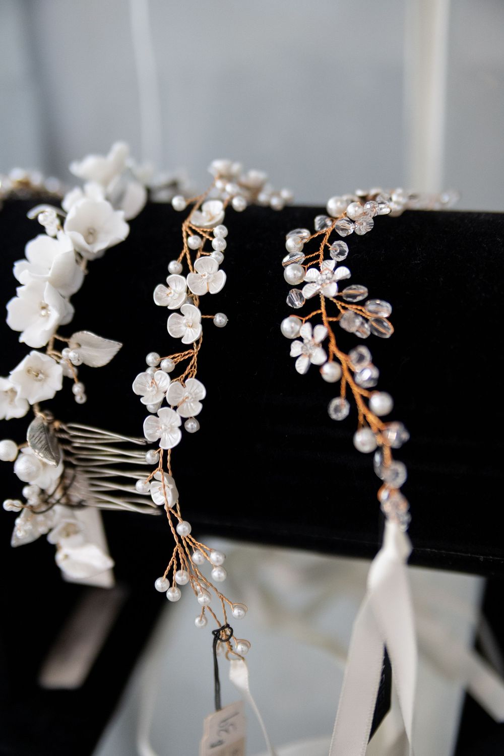 Delicate white floral hair accessories with pearl and crystal details arranged in a bridal hairpiece collection.