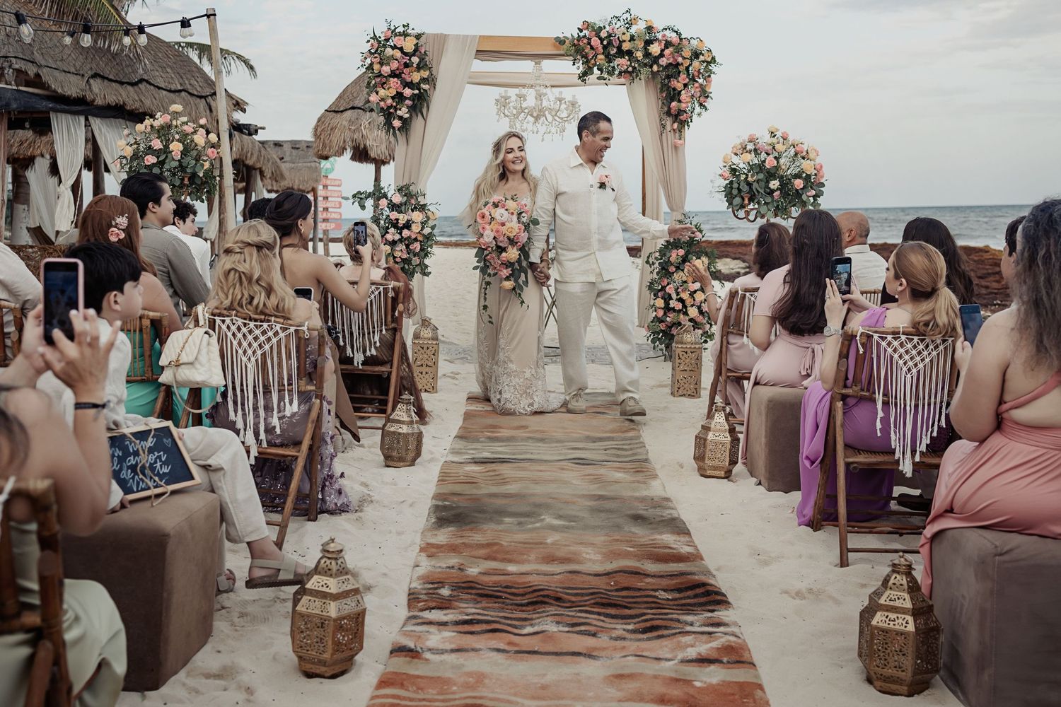 Julieta and Arturo walk down the aisle hand in hand after renewing their vows at Punta Xcalacoco Beach in Playa del Carmen.