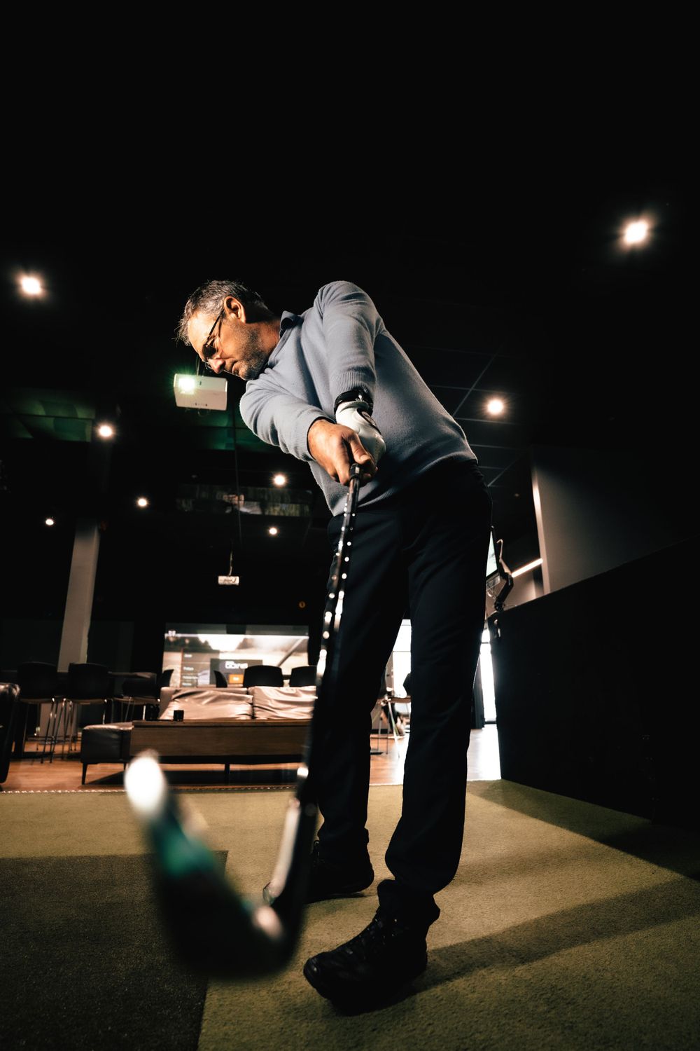 Person playing mini golf in a dimly lit indoor entertainment venue. Mtlshutter photography