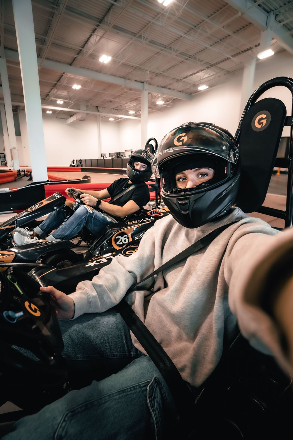 Person wearing a racing helmet taking a selfie while seated in a go-kart. Mtlshutter photography