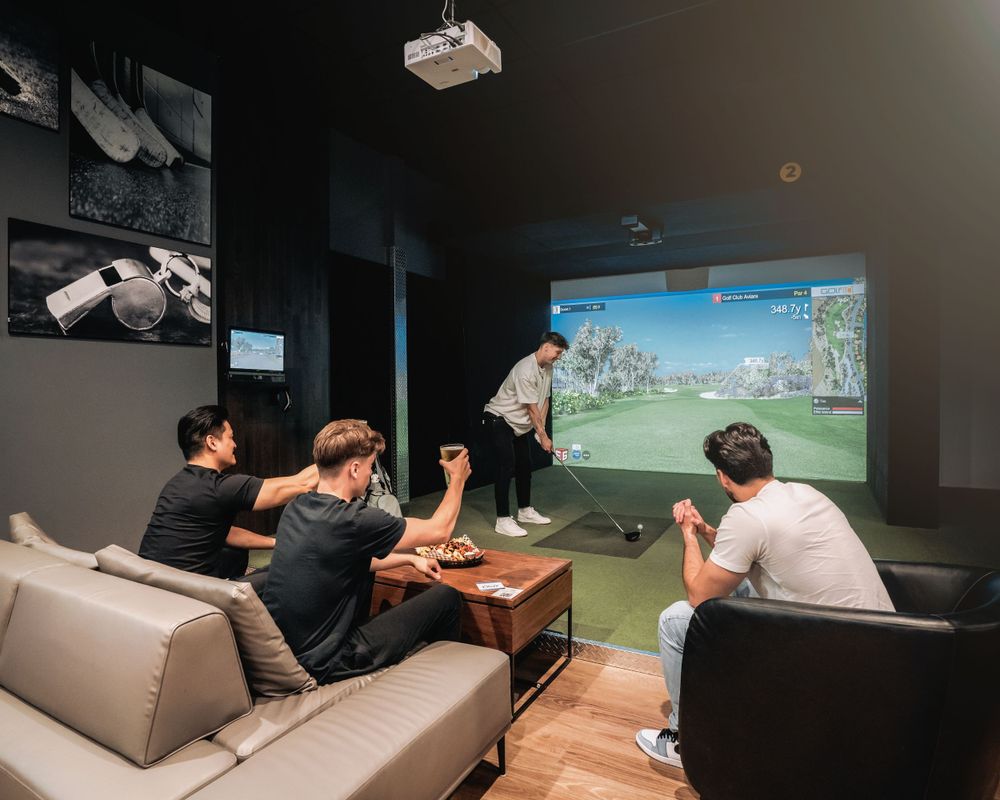 Group playing virtual golf simulator in a lounge setting. Mtlshutter photography
