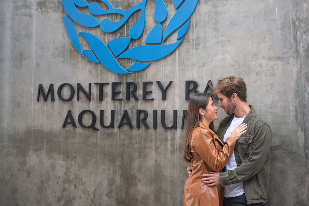 Intimate moment shared between couple at the Monterey Bay Aquarium entrance.