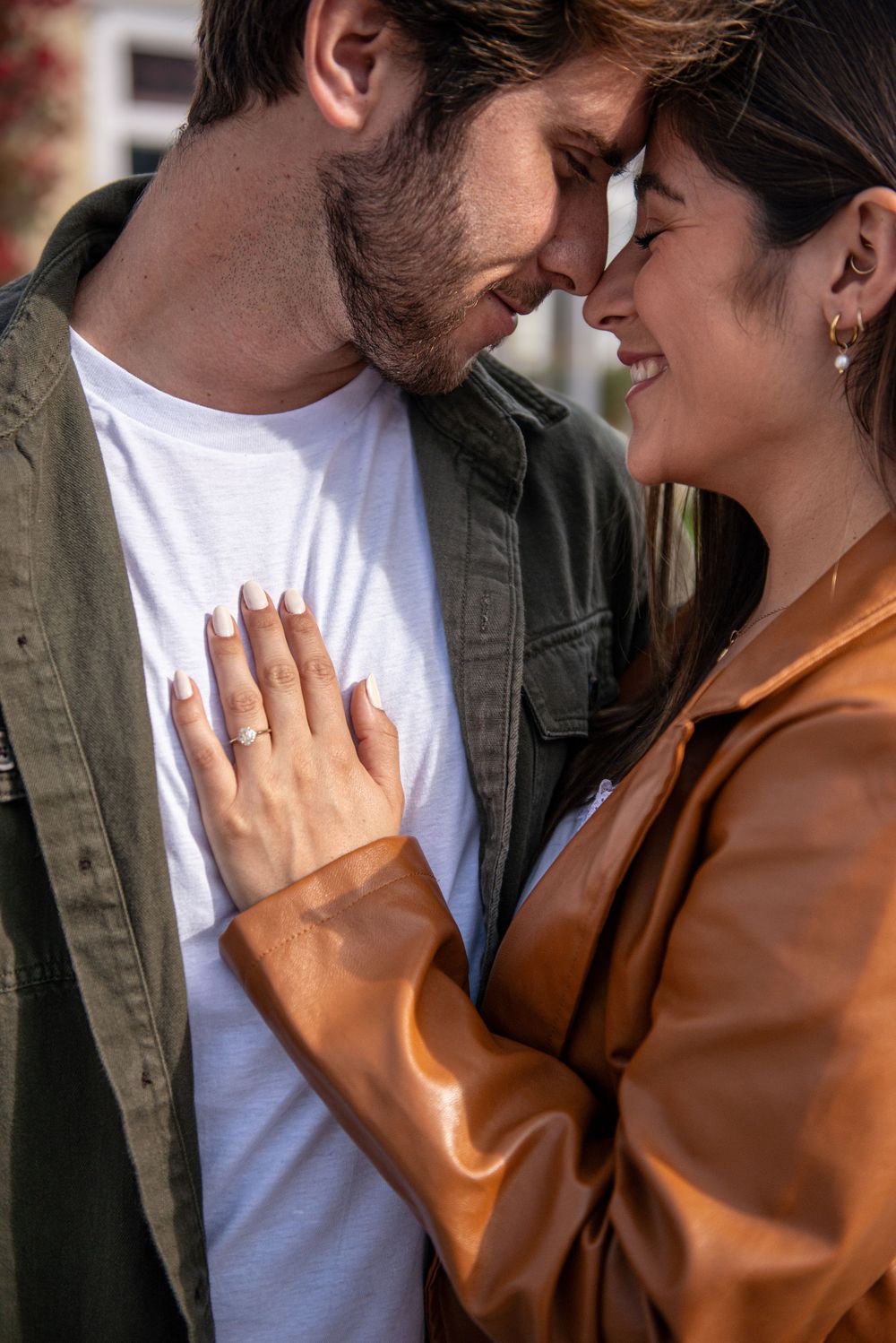 An intimate close-up shot of a couple embracing outdoors.