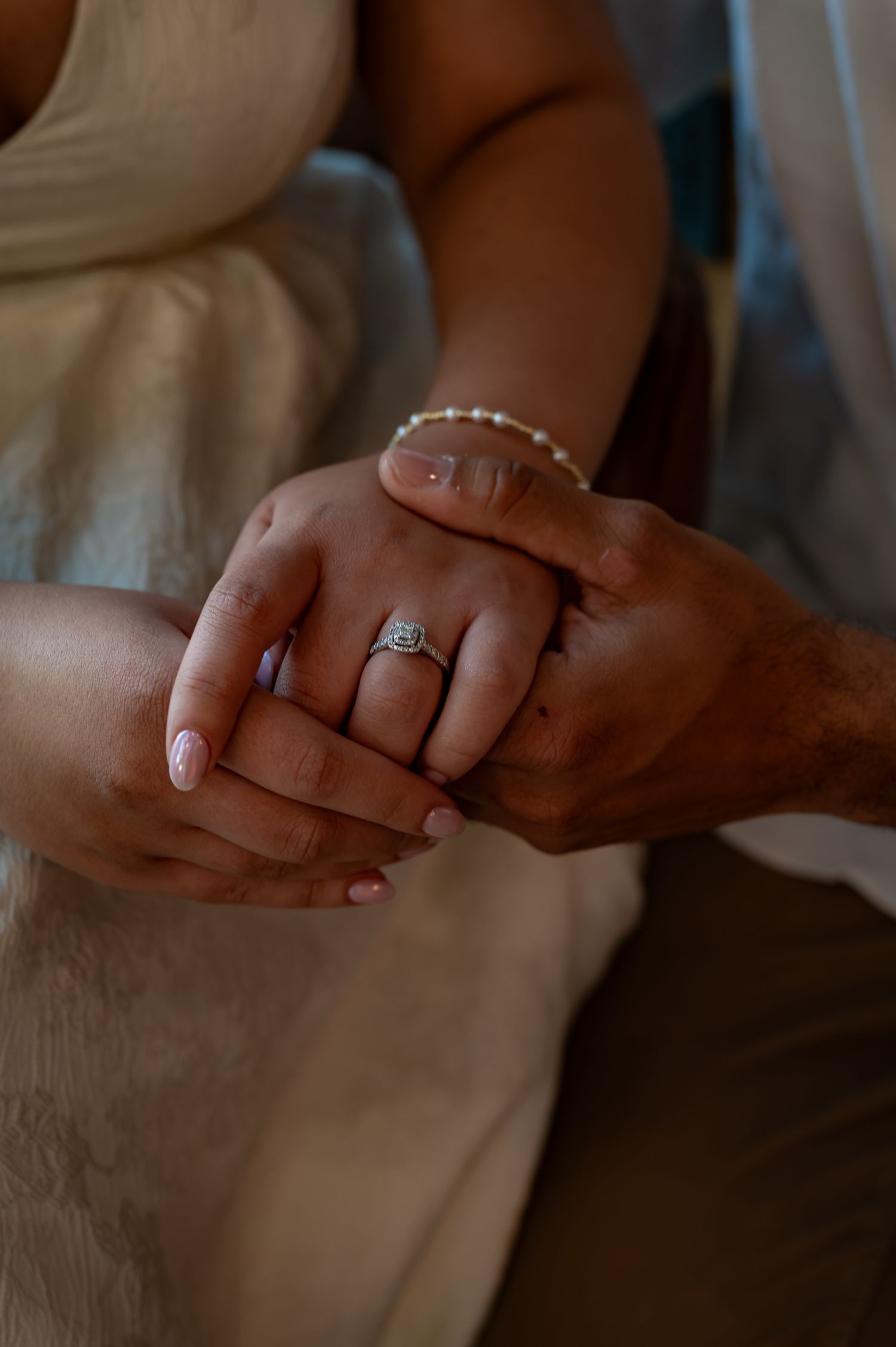 Close-up of hands exchanging an engagement ring during a romantic proposal moment.