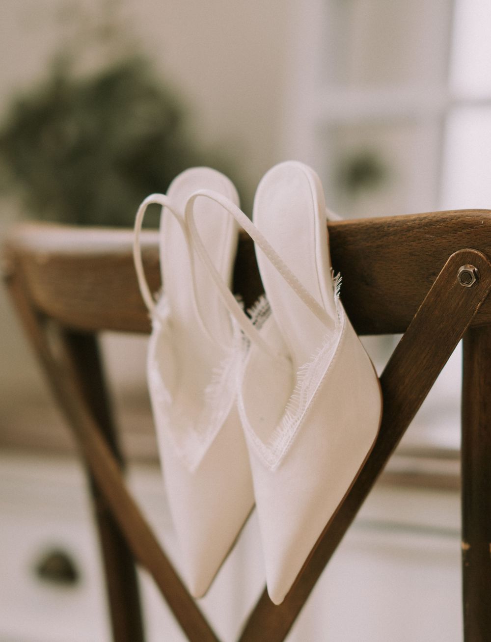 White cloth napkins are elegantly folded and displayed on dark wooden chairs at a formal dining setup.