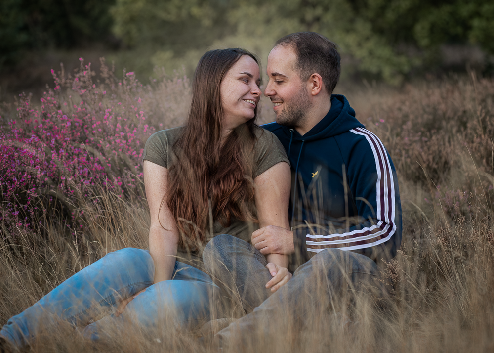 Koppel zittend bij elkaar in het bos.