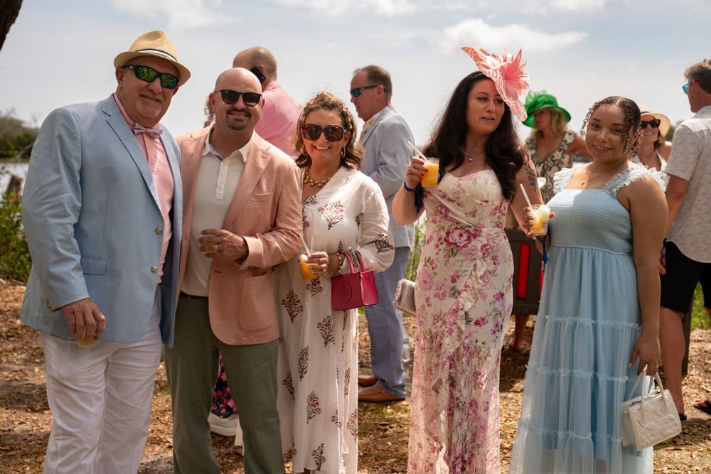 Tim Ellis capture Party guests in pastel and floral outfits gather outdoors for a social event at Airlie Luncheon Garden Party.