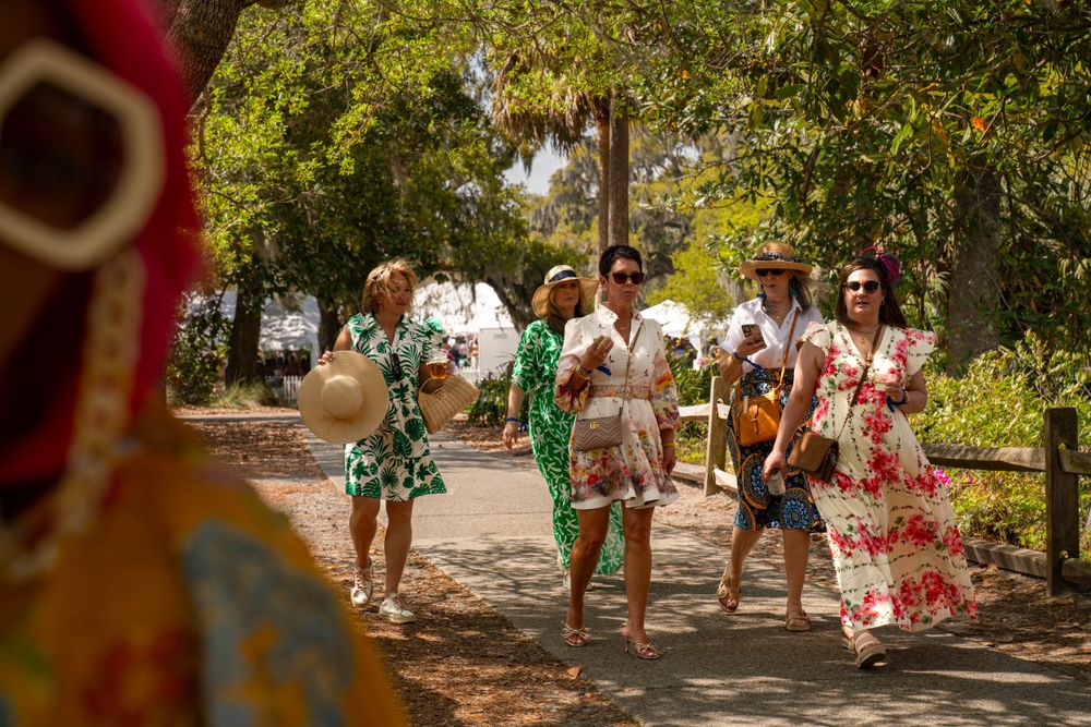 Photographer Tim Ellis captures a group that walks along a tree-lined path wearing festive spring attire and colorful outfits.