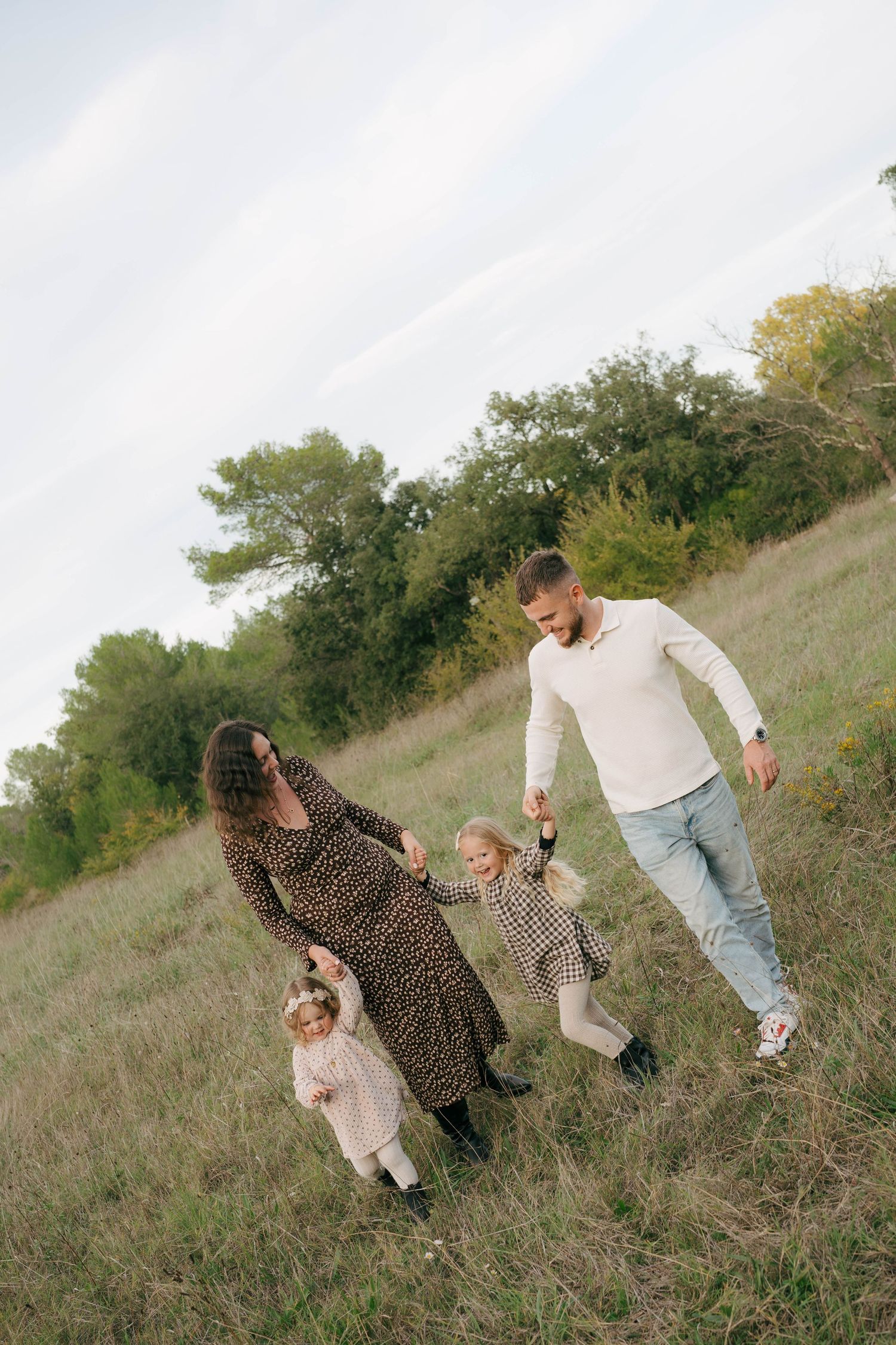 People walking up a grassy hillside in a sequence of casual candid moments captured in natural lighting.