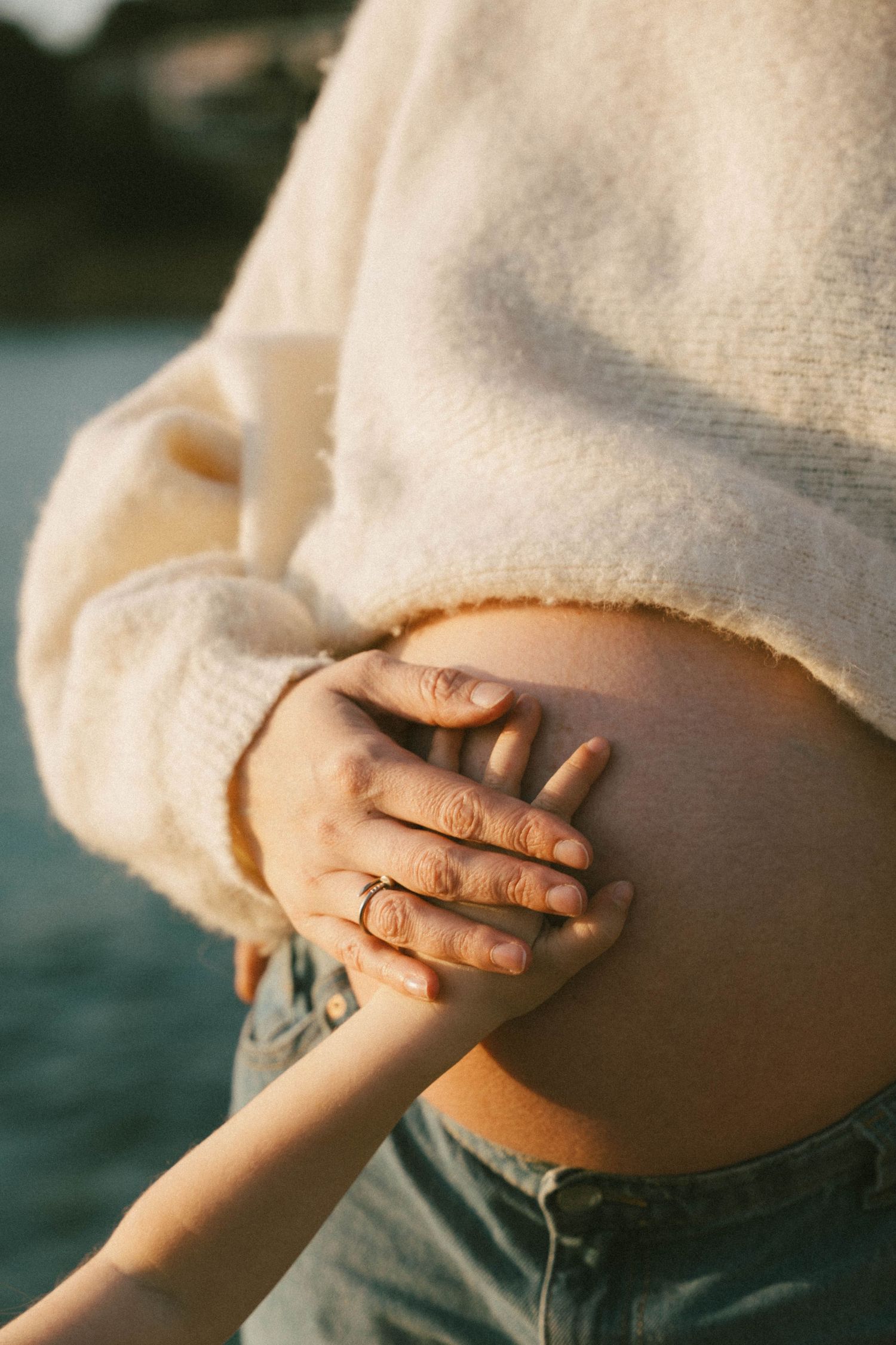 A series of photos showing a pregnant belly in warm sunlight with hands gently resting on the baby bump.
