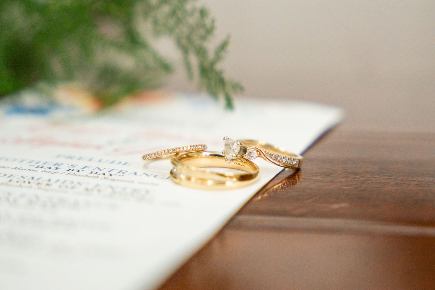 Wedding rings rest on an open book with handwritten text, creating a romantic detail shot of marriage vows.