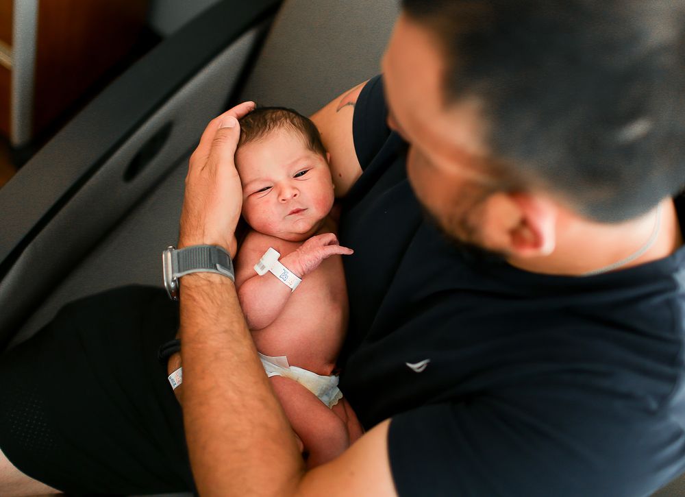 daddy snuggling newborn baby close to his chest