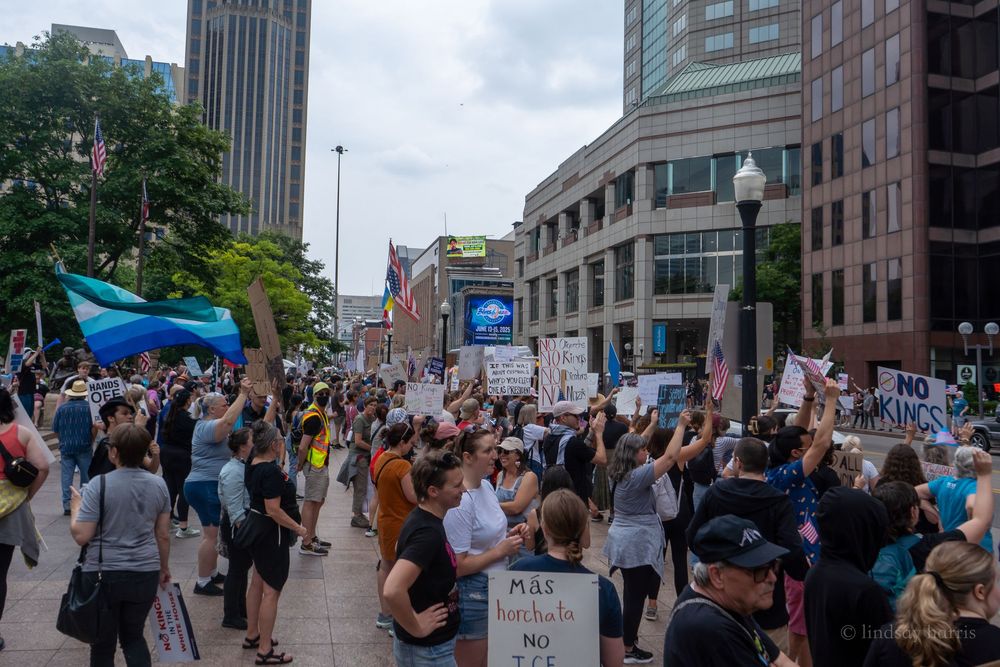 Large crowd of protesters gathered outside urban buildings during a demonstration with signs and flags in columbus oh.