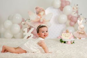 A series of baby milestone photos showing a newborn growing into a sitting position on soft white blankets.