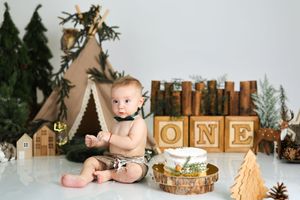 Woodland themed birthday setup with gold lettering and forest decorations.
