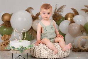 Neutral toned cake smash setup with bunny decorations and natural textures.