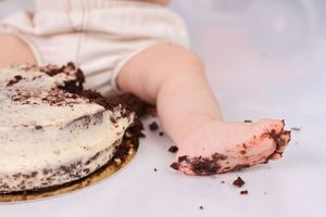 Artistic closeup of chocolate cake smash aftermath on white background.