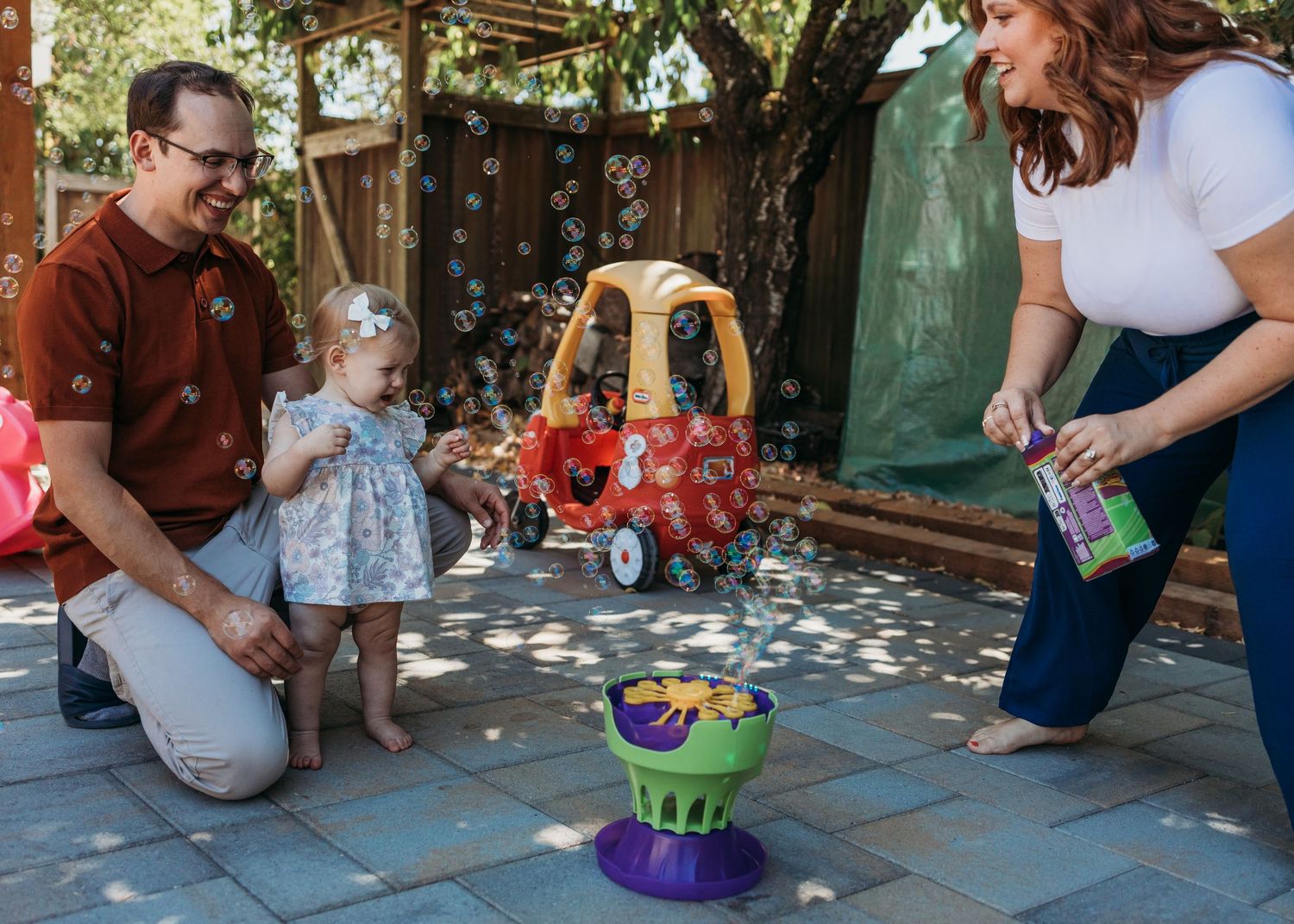 Kids sit on colorful play spots along a wooden deck while participating in an outdoor activity session.